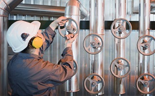 Engineer tightening a valve Engineer tightening a valve